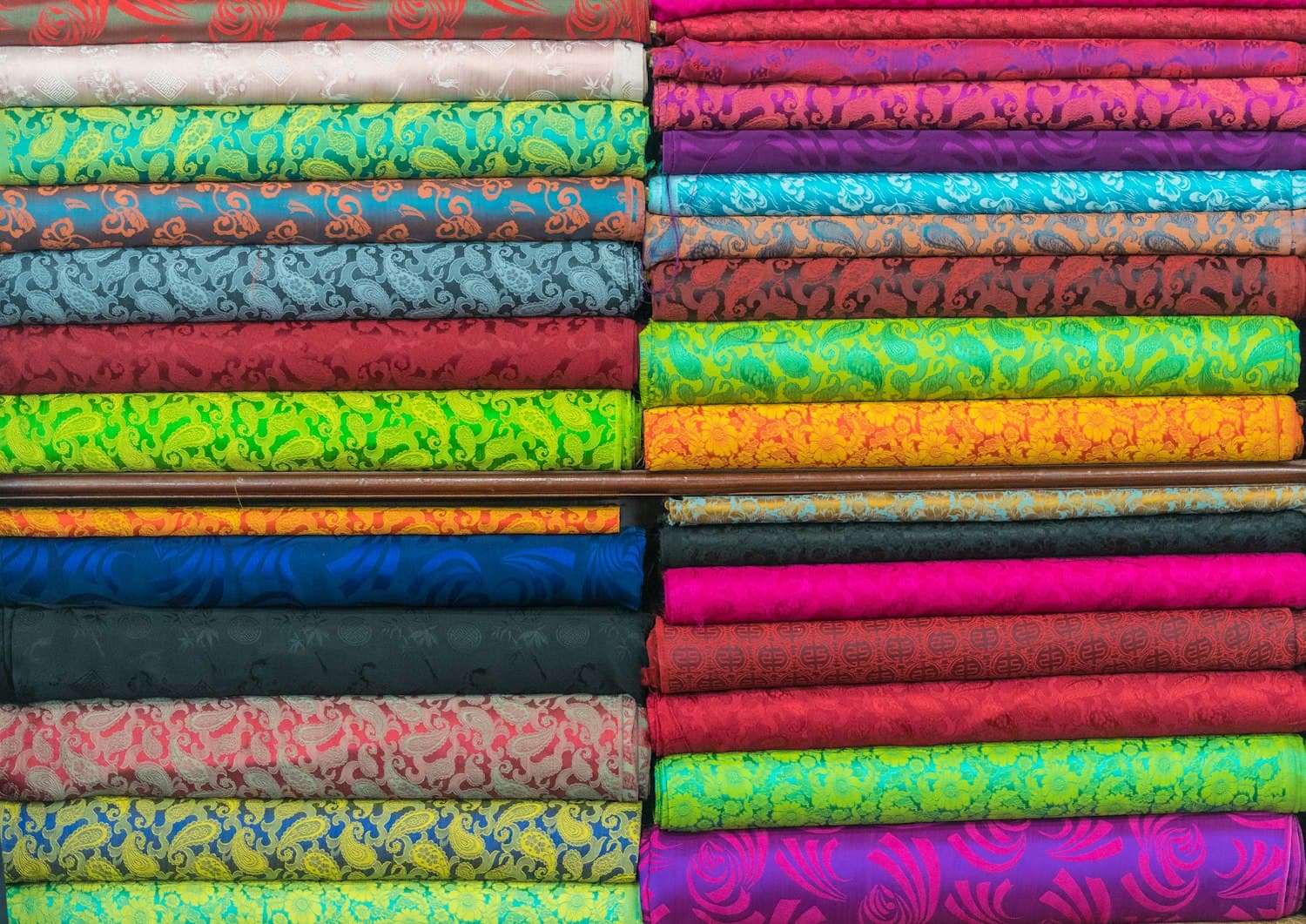 Bales of fabric stacked on the warehouse shelves